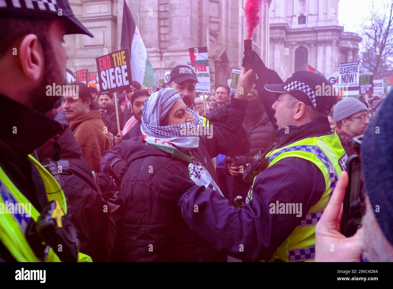 Londra, Regno Unito. 13 gennaio 2024. Agenti di polizia arruolati dal Galles confiscano un fumo da un manifestante. Migliaia di manifestanti pro-palestinesi hanno marciato dalla City di Londra a Parliament Square, chiedendo un immediato cessate il fuoco. Nonostante le proteste di massa a livello globale, e la settima marcia nazionale, non ci sono segni di avvenimento non appena il numero di morti palestinesi sale a 23.000 e migliaia di persone rimangono ferite, affrontando condizioni terribili all'interno delle poche strutture mediche funzionanti. Credito: Fotografia dell'undicesima ora/Alamy Live News Foto Stock