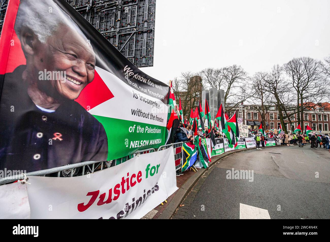 Un cartello con un ritratto di Nelson Rolihlahla Mandela, durante l'audizione della Corte internazionale di giustizia (ICJ). Centinaia di sostenitori pro-palestinesi e alcuni pro-israeliani sono stati tenuti ben separati oggi, al di fuori della Corte internazionale di giustizia (ICJ) o del Palazzo della Pace dell'Aia, il secondo giorno dell'udienza. Il Sudafrica ha accusato Israele di genocidio nei confronti del popolo palestinese. Oggi, gli israeliani hanno avuto la possibilità di difendersi in tribunale e hanno respinto con veemenza le accuse come "infondate” e antisemite. A Gaza, più di 23.800 persone - per lo più donne e bambini Foto Stock
