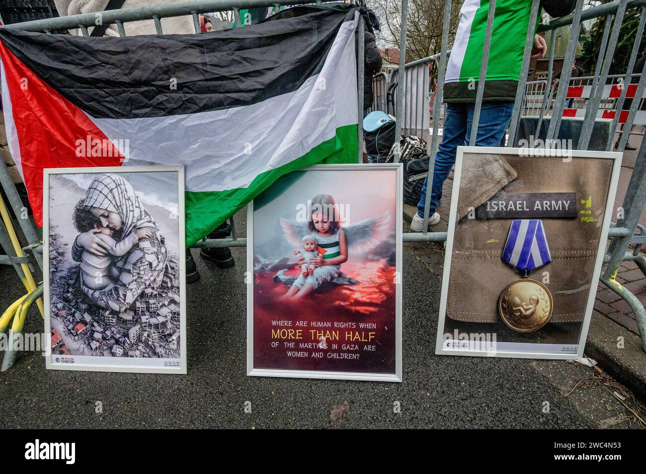 Manifesti d'arte raffiguranti gli orrori di Gaza, durante l'audizione della Corte internazionale di giustizia (ICJ). Centinaia di sostenitori pro-palestinesi e alcuni pro-israeliani sono stati tenuti ben separati oggi, al di fuori della Corte internazionale di giustizia (ICJ) o del Palazzo della Pace dell'Aia, il secondo giorno dell'udienza. Il Sudafrica ha accusato Israele di genocidio nei confronti del popolo palestinese. Oggi, gli israeliani hanno avuto la possibilità di difendersi in tribunale e hanno respinto con veemenza le accuse come "infondate” e antisemite. A Gaza, più di 23.800 persone - per lo più donne e bambini hanno api Foto Stock