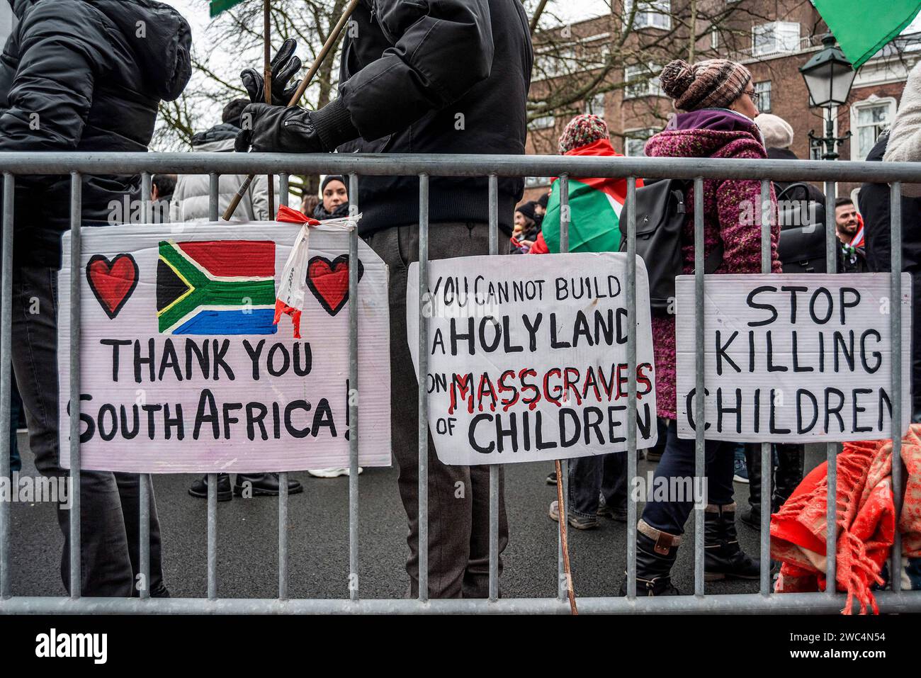 I manifestanti si trovano in piedi nei prossimi cartelli che esprimono le loro opinioni durante l'audizione della Corte internazionale di giustizia (ICJ). Centinaia di sostenitori pro-palestinesi e alcuni pro-israeliani sono stati tenuti ben separati oggi, al di fuori della Corte internazionale di giustizia (ICJ) o del Palazzo della Pace dell'Aia, il secondo giorno dell'udienza. Il Sudafrica ha accusato Israele di genocidio nei confronti del popolo palestinese. Oggi, gli israeliani hanno avuto la possibilità di difendersi in tribunale e hanno respinto con veemenza le accuse come "infondate” e antisemite. A Gaza, più di 23.800 persone - per lo più donne e bambini Foto Stock