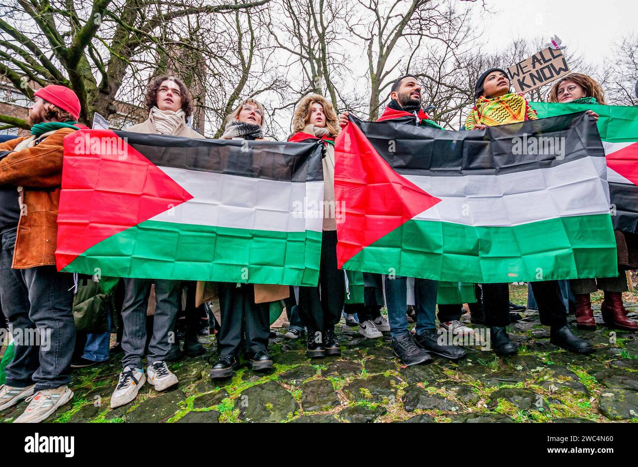 Sostenitore pro-palestinese con bandiere che manifestano il loro sostegno, durante l’audizione della Corte internazionale di giustizia (ICJ). Centinaia di sostenitori pro-palestinesi e alcuni pro-israeliani sono stati tenuti ben separati oggi, al di fuori della Corte internazionale di giustizia (ICJ) o del Palazzo della Pace dell'Aia, il secondo giorno dell'udienza. Il Sudafrica ha accusato Israele di genocidio nei confronti del popolo palestinese. Oggi, gli israeliani hanno avuto la possibilità di difendersi in tribunale e hanno respinto con veemenza le accuse come "infondate” e antisemite. A Gaza, più di 23.800 persone - per lo più donne e bambini Foto Stock