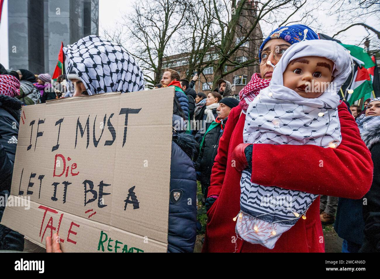 Una donna palestinese con bambola che rappresenta un bambino di Gaza, durante l'udienza della Corte internazionale di giustizia (ICJ). Centinaia di sostenitori pro-palestinesi e alcuni pro-israeliani sono stati tenuti ben separati oggi, al di fuori della Corte internazionale di giustizia (ICJ) o del Palazzo della Pace dell'Aia, il secondo giorno dell'udienza. Il Sudafrica ha accusato Israele di genocidio nei confronti del popolo palestinese. Oggi, gli israeliani hanno avuto la possibilità di difendersi in tribunale e hanno respinto con veemenza le accuse come "infondate” e antisemite. A Gaza, più di 23.800 persone - per lo più donne e.. Foto Stock