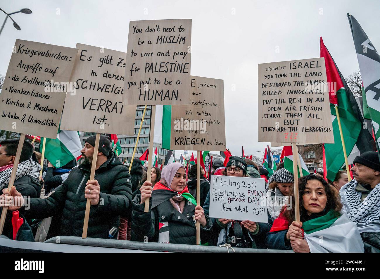 I manifestanti detengono bandiere e cartelli che esprimono la loro opinione durante l'udienza della Corte internazionale di giustizia (ICJ). Centinaia di sostenitori pro-palestinesi e alcuni pro-israeliani sono stati tenuti ben separati oggi, al di fuori della Corte internazionale di giustizia (ICJ) o del Palazzo della Pace dell'Aia, il secondo giorno dell'udienza. Il Sudafrica ha accusato Israele di genocidio nei confronti del popolo palestinese. Oggi, gli israeliani hanno avuto la possibilità di difendersi in tribunale e hanno respinto con veemenza le accuse come "infondate” e antisemite. A Gaza, più di 23.800 persone - per lo più donne e bambini Foto Stock