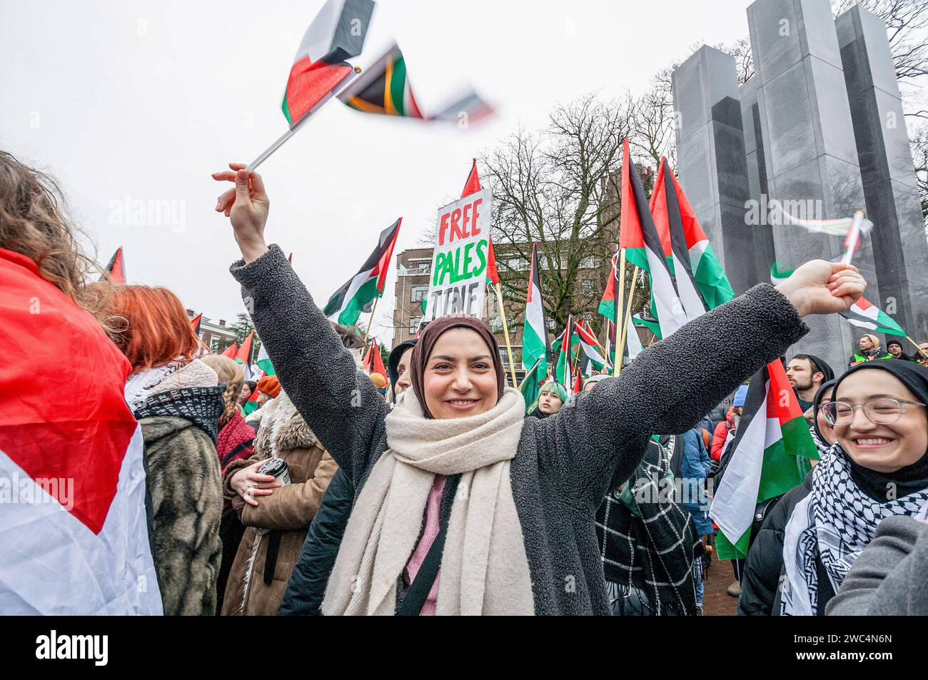 Una giovane donna palestinese sventola una bandiera sudafricana e palestinese, durante l'audizione della Corte internazionale di giustizia (ICJ). Centinaia di sostenitori pro-palestinesi e alcuni pro-israeliani sono stati tenuti ben separati oggi, al di fuori della Corte internazionale di giustizia (ICJ) o del Palazzo della Pace dell'Aia, il secondo giorno dell'udienza. Il Sudafrica ha accusato Israele di genocidio nei confronti del popolo palestinese. Oggi, gli israeliani hanno avuto la possibilità di difendersi in tribunale e hanno respinto con veemenza le accuse come "infondate” e antisemite. A Gaza, più di 23.800 persone - per lo più donne Foto Stock