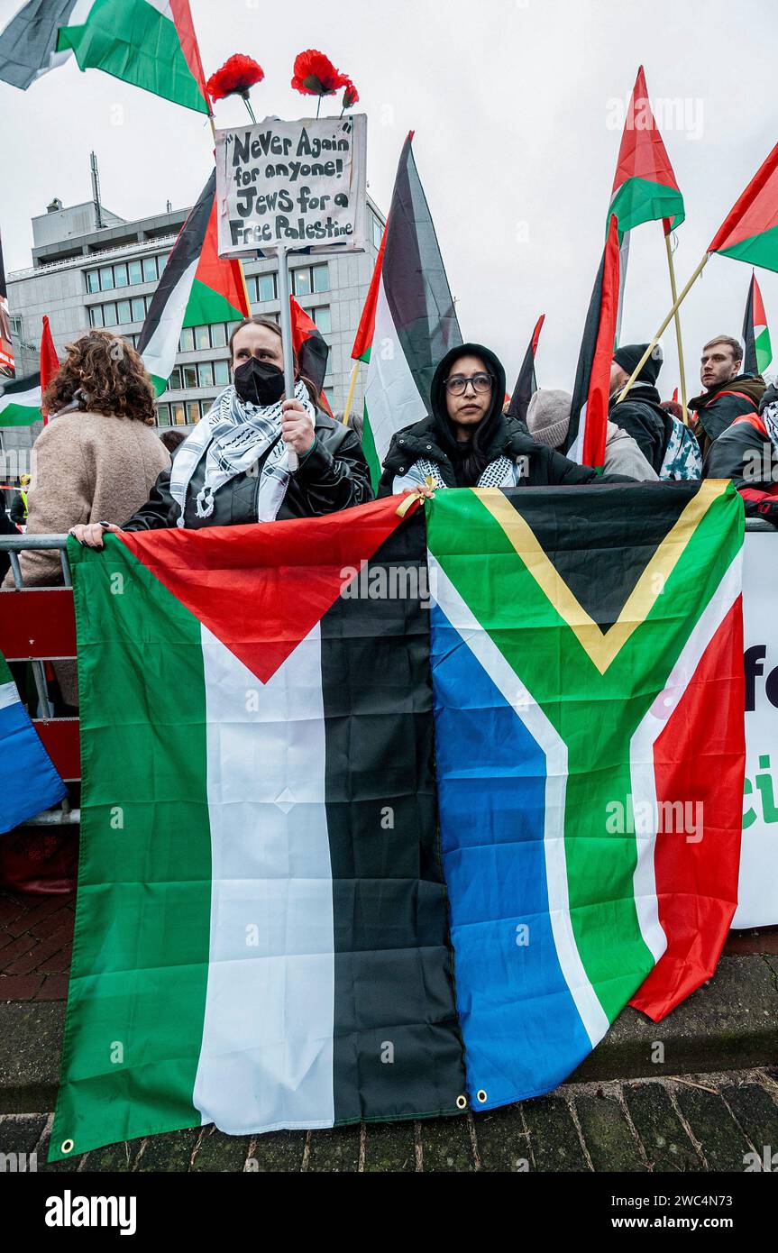 Sostenitori pro-palestinesi con bandiere che mostrano il loro sostegno, durante l’audizione della Corte internazionale di giustizia (ICJ). Centinaia di sostenitori pro-palestinesi e alcuni pro-israeliani sono stati tenuti ben separati oggi, al di fuori della Corte internazionale di giustizia (ICJ) o del Palazzo della Pace dell'Aia, il secondo giorno dell'udienza. Il Sudafrica ha accusato Israele di genocidio nei confronti del popolo palestinese. Oggi, gli israeliani hanno avuto la possibilità di difendersi in tribunale e hanno respinto con veemenza le accuse come "infondate” e antisemite. A Gaza, più di 23.800 persone - per lo più donne e bambini Foto Stock