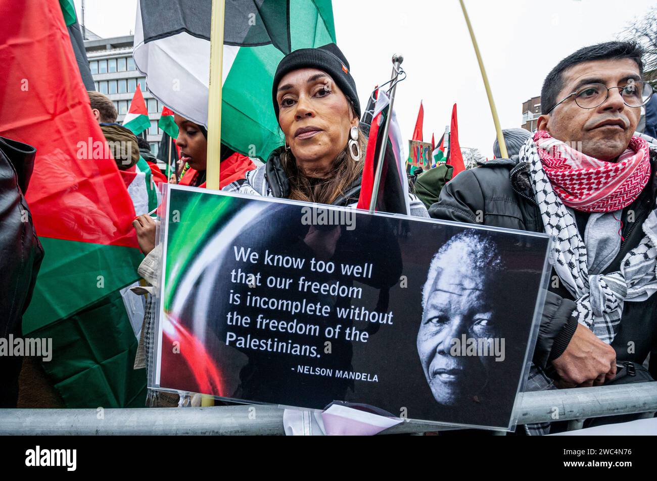 Un manifestante tiene un cartello con un ritratto di Nelson Rolihlahla Mandela, durante l'udienza della Corte Internazionale di giustizia (ICJ). Centinaia di sostenitori pro-palestinesi e alcuni pro-israeliani sono stati tenuti ben separati oggi, al di fuori della Corte internazionale di giustizia (ICJ) o del Palazzo della Pace dell'Aia, il secondo giorno dell'udienza. Il Sudafrica ha accusato Israele di genocidio nei confronti del popolo palestinese. Oggi, gli israeliani hanno avuto la possibilità di difendersi in tribunale e hanno respinto con veemenza le accuse come "infondate” e antisemite. A Gaza, più di 23.800 persone - per lo più W Foto Stock