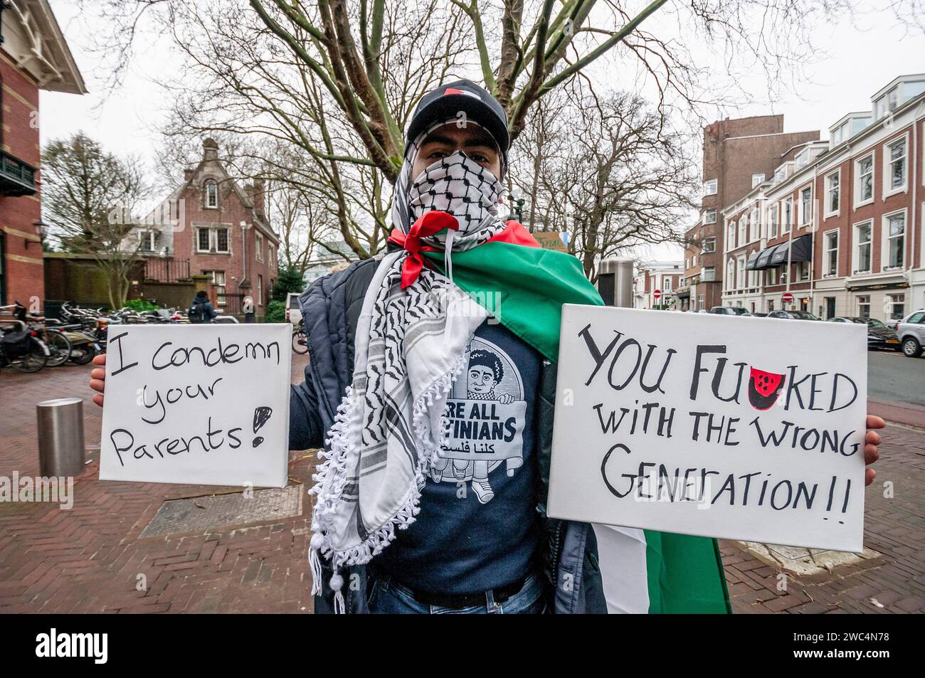 Un manifestante tiene cartelli che esprimono la sua opinione, durante l'audizione della Corte internazionale di giustizia (ICJ). Centinaia di sostenitori pro-palestinesi e alcuni pro-israeliani sono stati tenuti ben separati oggi, al di fuori della Corte internazionale di giustizia (ICJ) o del Palazzo della Pace dell'Aia, il secondo giorno dell'udienza. Il Sudafrica ha accusato Israele di genocidio nei confronti del popolo palestinese. Oggi, gli israeliani hanno avuto la possibilità di difendersi in tribunale e hanno respinto con veemenza le accuse come "infondate” e antisemite. A Gaza, più di 23.800 persone - per lo più donne e bambini lo hanno fatto Foto Stock