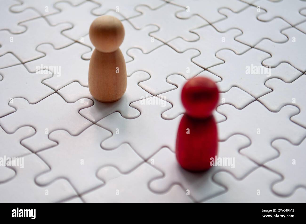Bambole di legno rosse e marroni su puzzle. Foto Stock