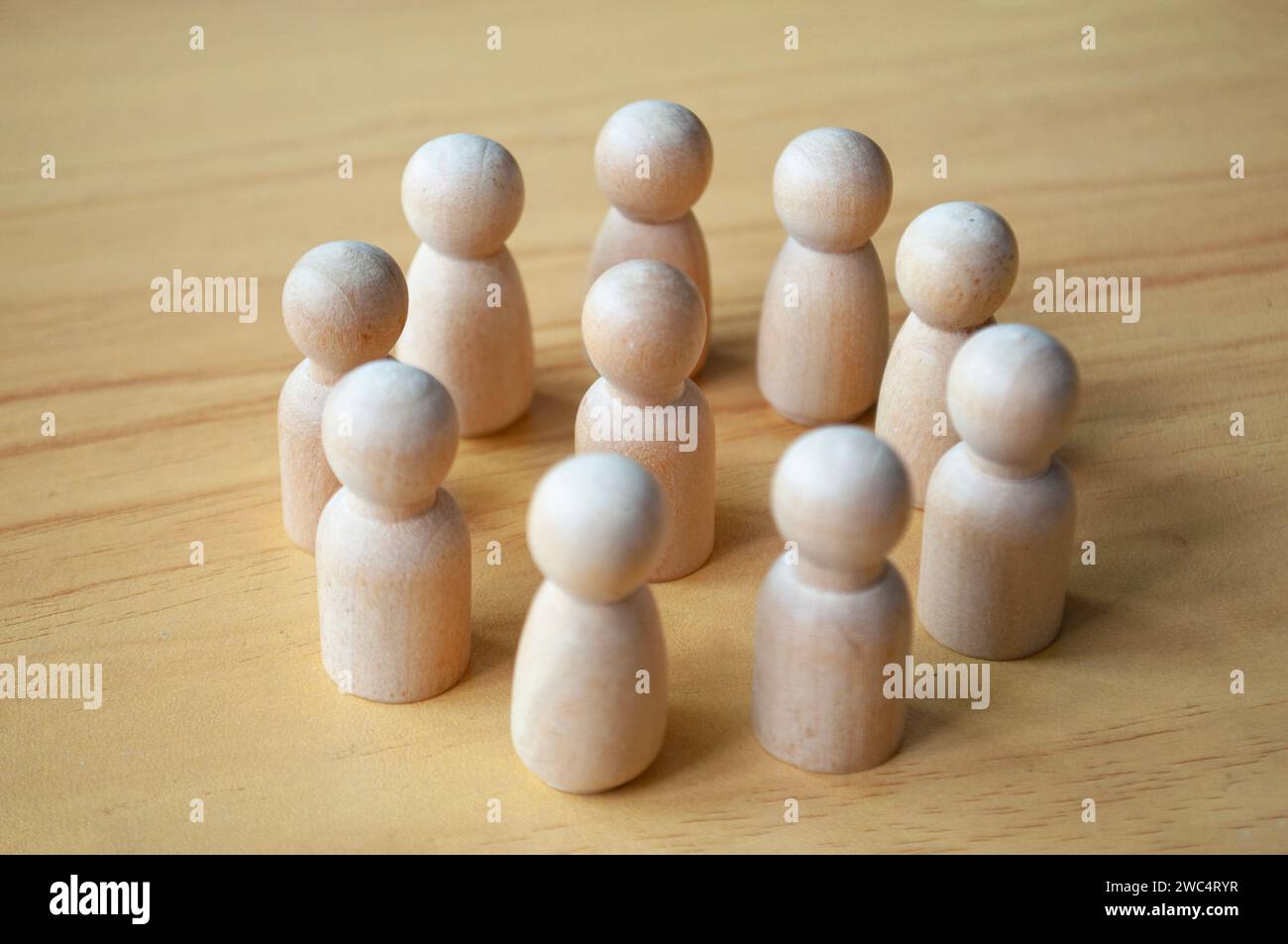 Una bambola di legno circondata da altre bambole. Rappresentare la leadership o le molestie. Foto Stock