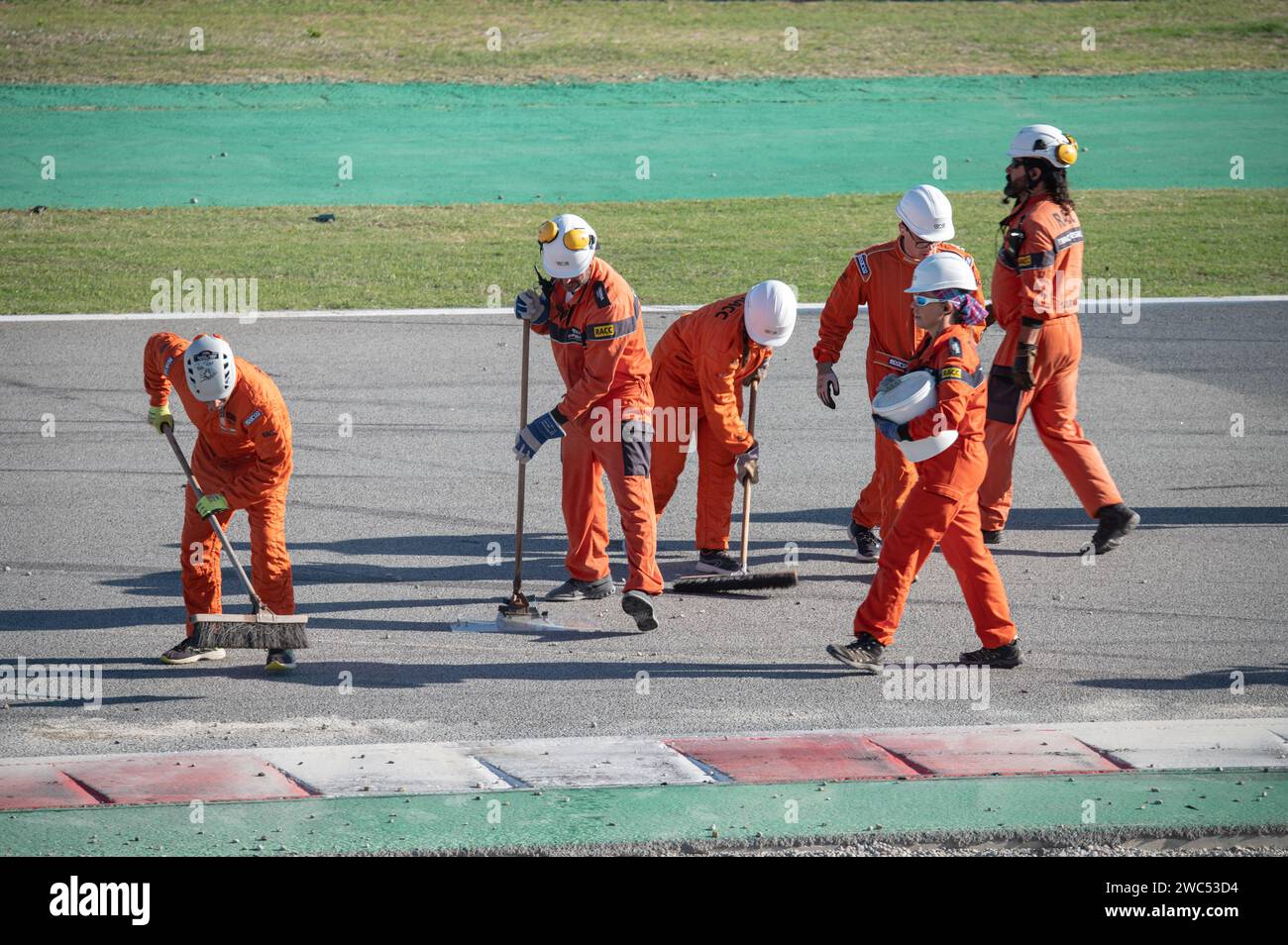 Il team di sceriffi di pista pulisce l'asfalto dopo un incidente di gara Foto Stock