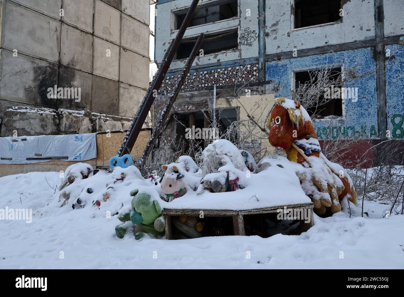 Un monumento spontaneo con giocattoli per bambini ricoperti di neve dedicato alle vittime dell'attacco di razzi russi visto dall'edificio dell'appartamento che è stato pesantemente danneggiato dai bombardamenti russi a Zaporizhzhia. Il presidente ucraino Volodymyr Zelenskiy ha detto di essere più positivo ora che lo era il mese scorso che il suo paese avrebbe ottenuto nuovi aiuti finanziari dagli Stati Uniti. Ma non c'era alcuna indicazione a Washington che l'approvazione del Congresso per un pacchetto di aiuti proposto dalla Casa Bianca sarebbe stata imminente in qualsiasi momento presto. (Foto di Andriy Andriyenko/SOPA Images/Sipa USA) Foto Stock