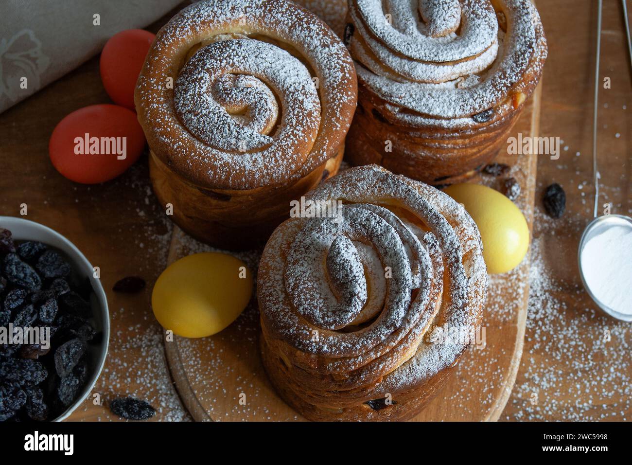 Dolci pasquali, kraffin con uva passa, frutta candita, cosparsa di zucchero in polvere. Primo piano della torta fatta in casa. Cruffin. Uova di Pasqua Foto Stock