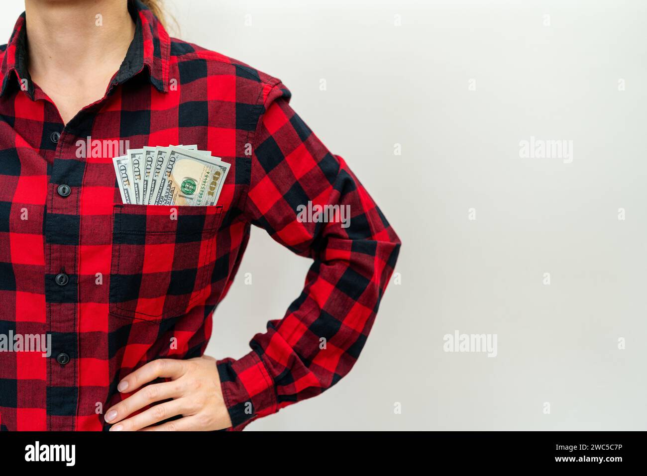 banconote da 100 dollari in tasca di camicia casual rossa di una donna. Foto Stock