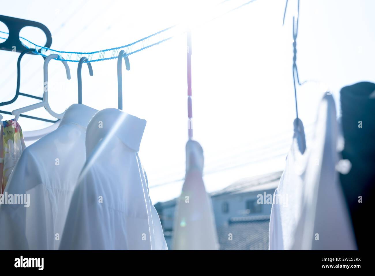 Asciugare gli indumenti al sole utilizzando una corda da bucato che tiene separati gli indumenti in condizioni di vento Foto Stock