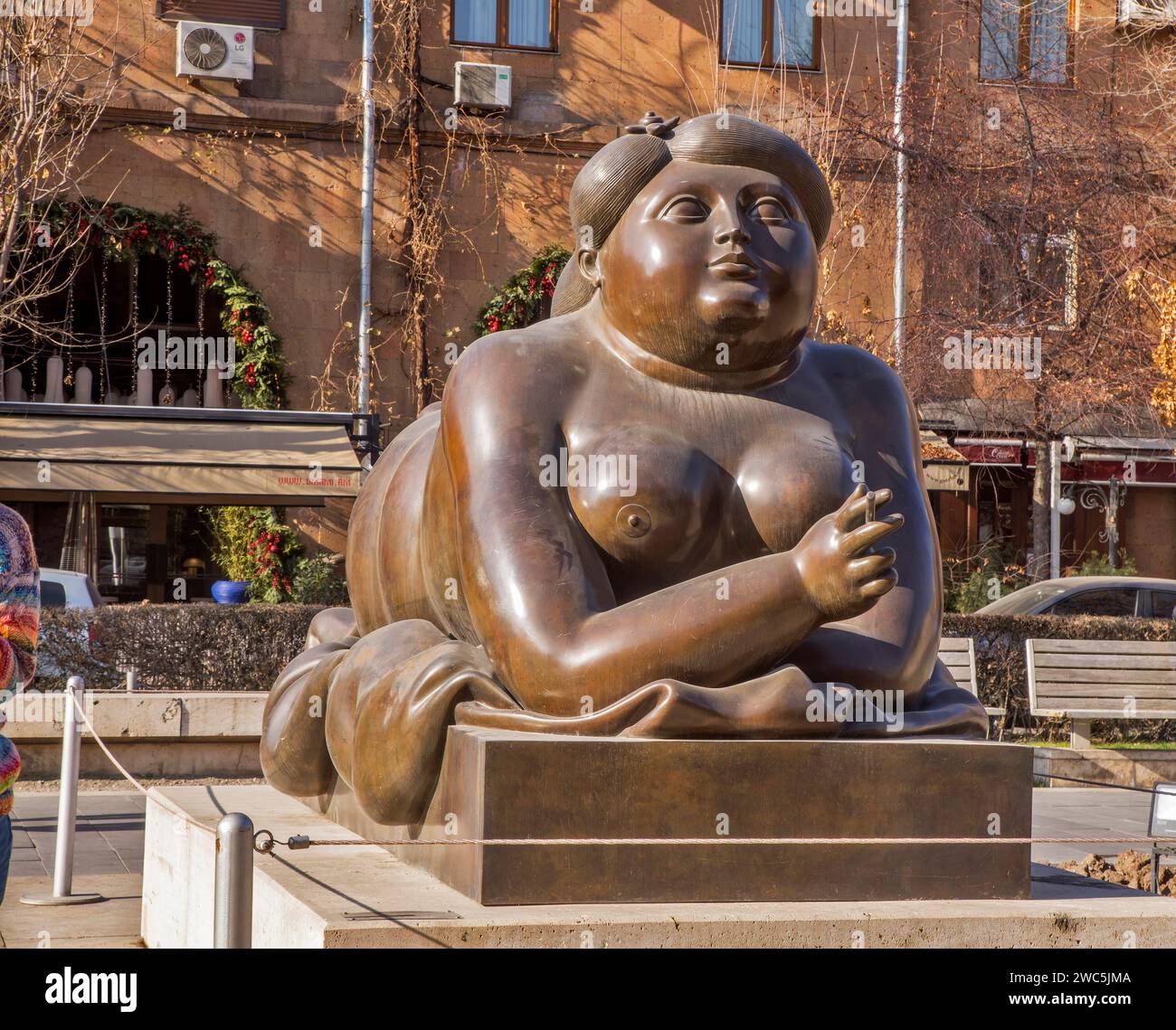 Donna che fuma una scultura di sigaretta di Fernando Botero di fronte alla cascata a Erevan. Armenia Foto Stock