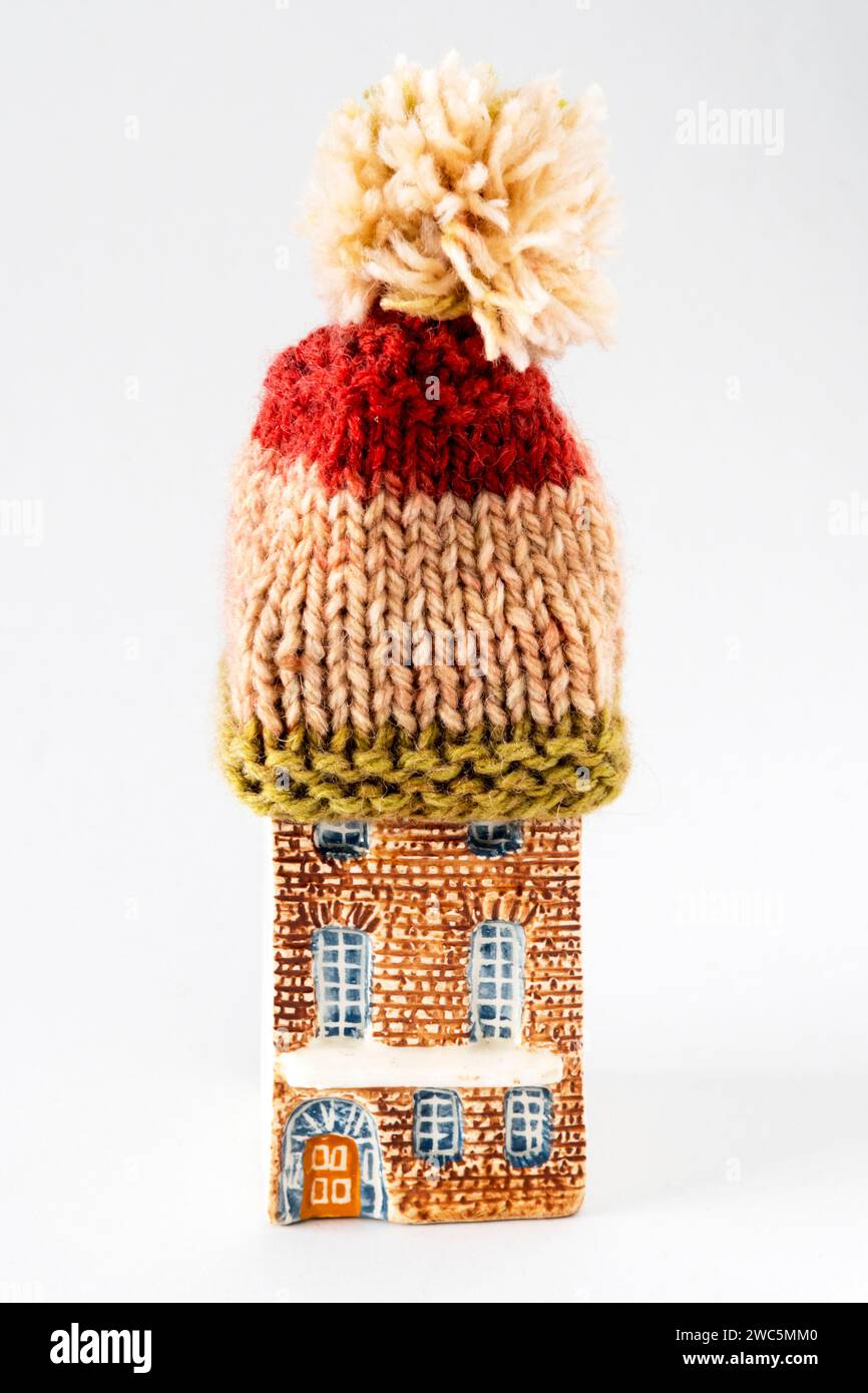 Una casa modello che indossa un bobble Hat in maglia di lana per tenersi al caldo. Tenere la casa al caldo. Foto Stock