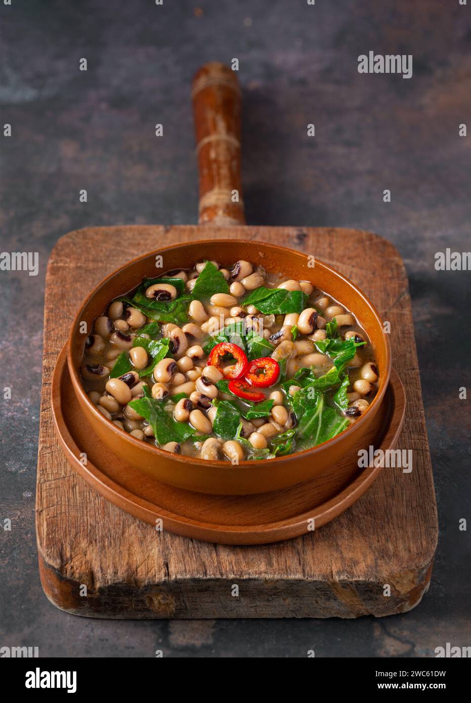 Versione vegana di piselli occhi neri e collarino verde in una ciotola marrone con spazio per la copia Foto Stock