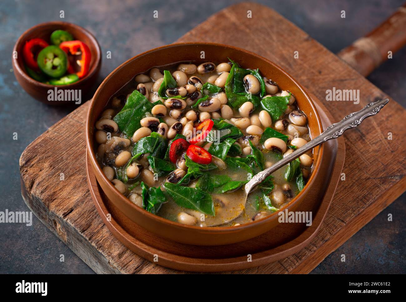 Piatto tradizionale DEGLI STATI UNITI del Sud con piselli occhi neri e verde collarino su un tagliere rustico con spazio per la copia Foto Stock