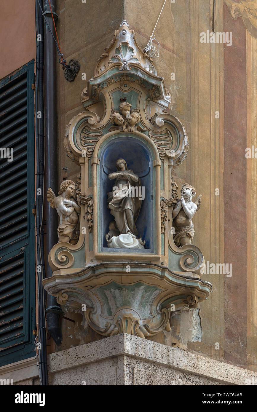 Venerazione della Vergine Maria con figure d'angelo su una casa d'angolo, nel centro storico di Genova, Italia Foto Stock