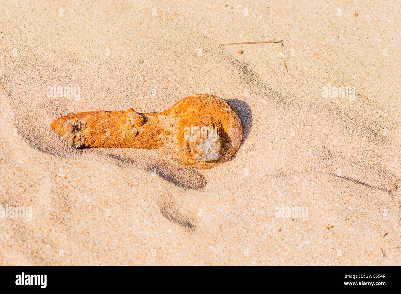Tubo di metallo arrugginito che si trova nella sabbia di una spiaggia Foto Stock
