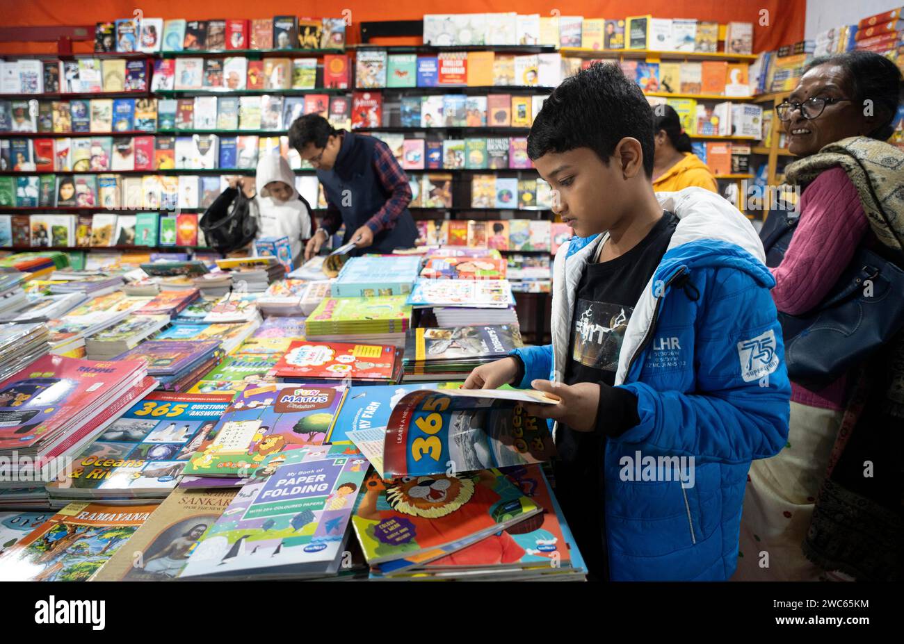 I lettori di libri navigano in una bancarella durante la fiera del libro di Assam, a Guwahati, Assam, India, il 29 dicembre 2023 Foto Stock