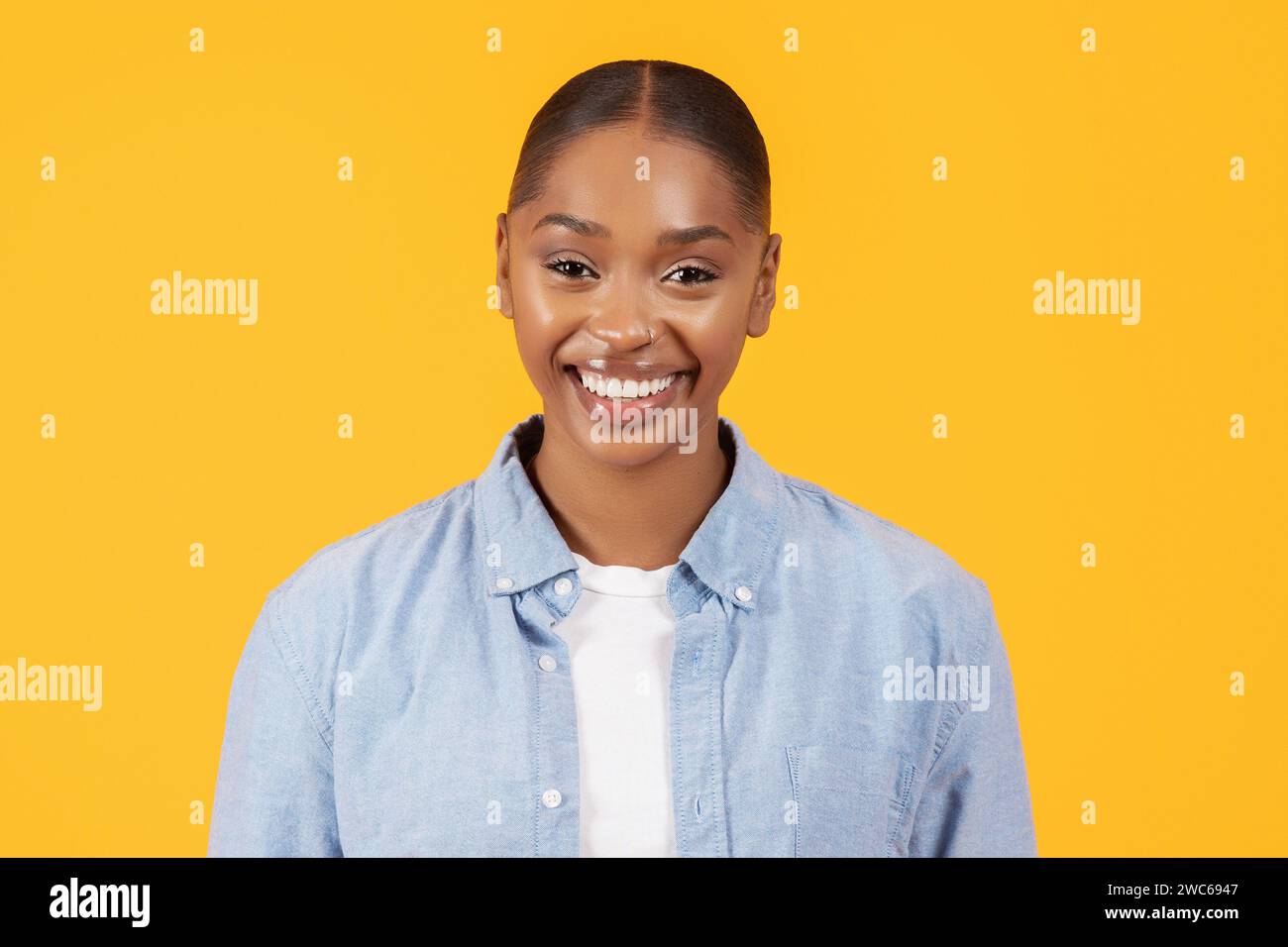 ritratto di happy black woman in abbigliamento denim, sfondo giallo Foto Stock