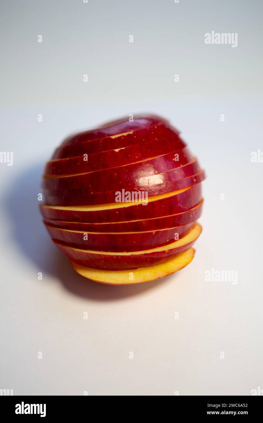 Mela rossa lucida con fette tagliate. Rimettere insieme a forma di mela. Foto Stock
