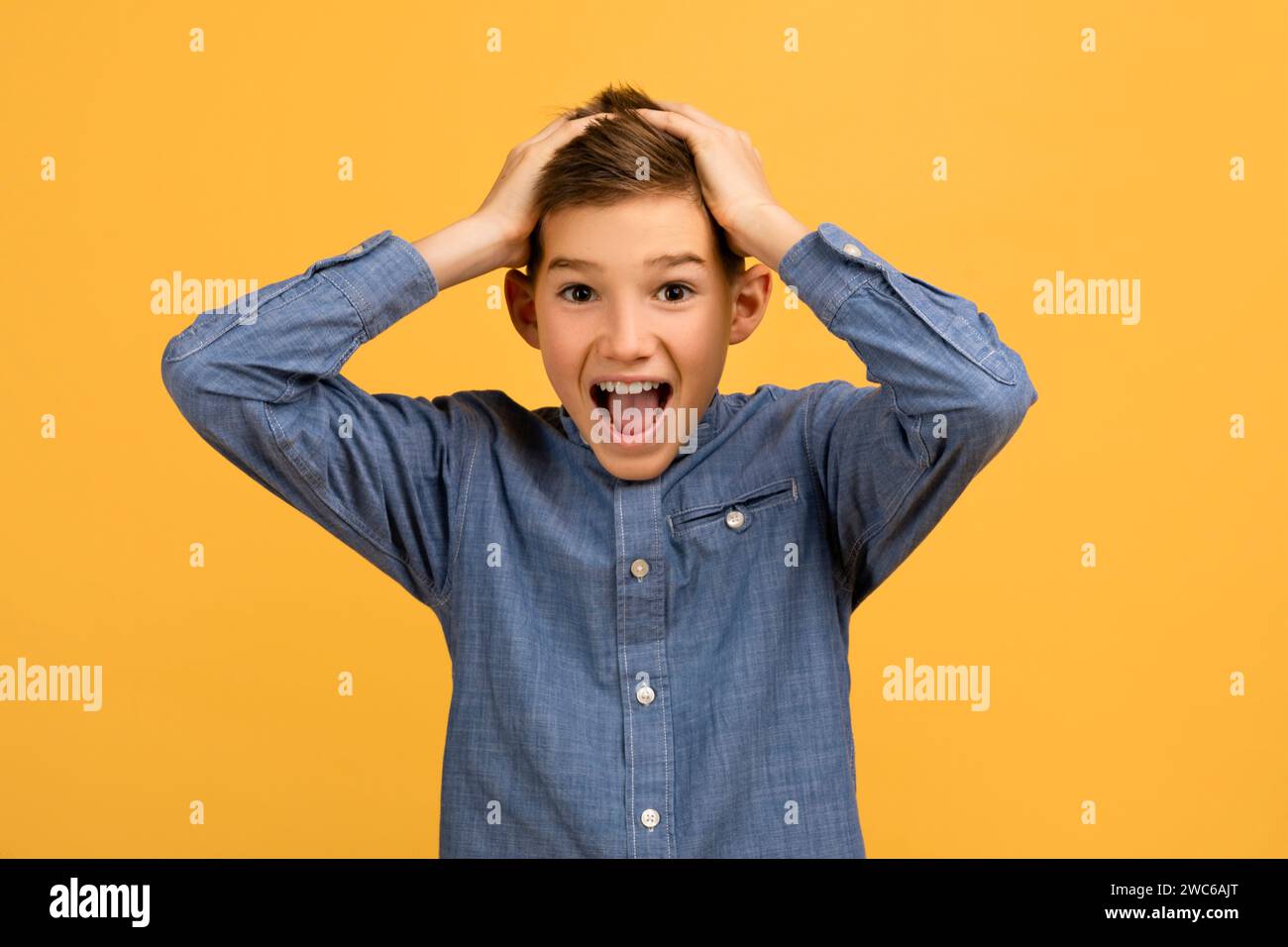 Wow. Ritratto di Shocked Teen Boy che tocca la testa e guarda la fotocamera Foto Stock