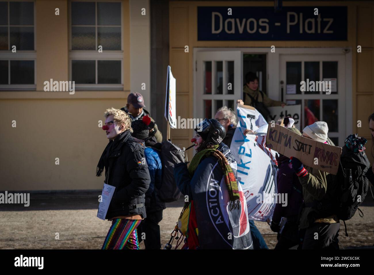 Davos, Svizzera. 14 gennaio 2024. Davos, CH 14 gennaio 2024. I manifestanti camminano oltre la stazione ferroviaria di Davos Platz per protestare contro il 54° Forum economico Mondiale. Centinaia di manifestanti si sono riuniti per esprimere preoccupazioni sull'agenda del WEF di quest'anno. Il Forum coinvolge i leader politici, commerciali e culturali della società per definire i programmi globali, regionali e industriali, che possono avere un impatto su tutti in tutto il mondo. Crediti: Andy Barton/Alamy Live News Foto Stock