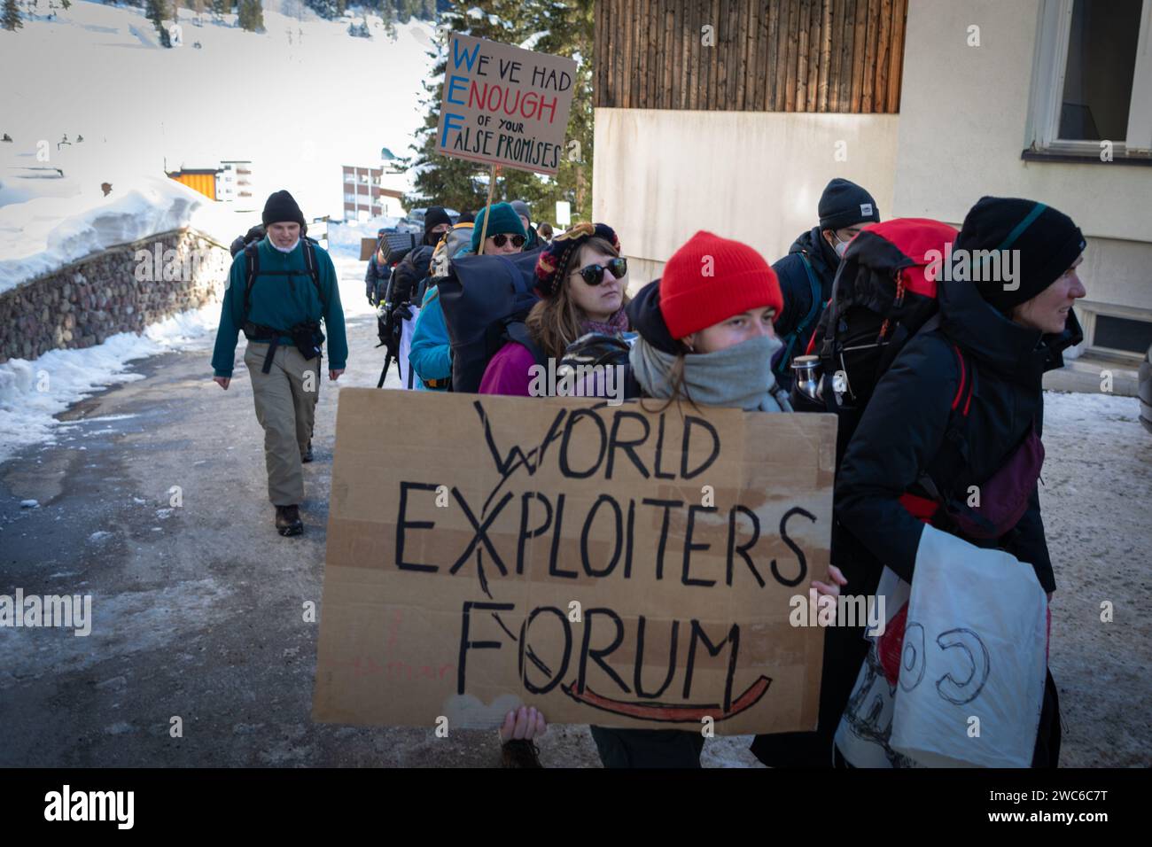 Davos, Svizzera. 14 gennaio 2024. Davos, CH 14 gennaio 2024. I manifestanti portano uno striscione a Davos per protestare contro il 54° Forum economico Mondiale. Centinaia di manifestanti si sono riuniti per esprimere preoccupazioni sull'agenda del WEF di quest'anno. Il Forum coinvolge i leader politici, commerciali e culturali della società per definire i programmi globali, regionali e industriali, che possono avere un impatto su tutti in tutto il mondo. Crediti: Andy Barton/Alamy Live News Foto Stock