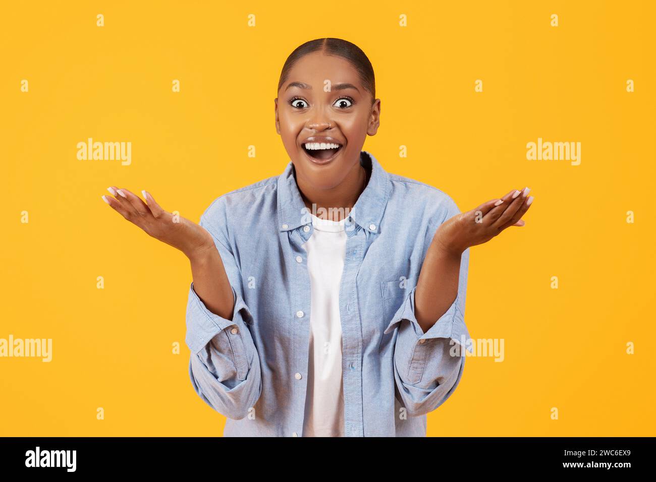 Ritratto di una giovane donna nera che urla OMG sentendosi eccitata, studio Foto Stock
