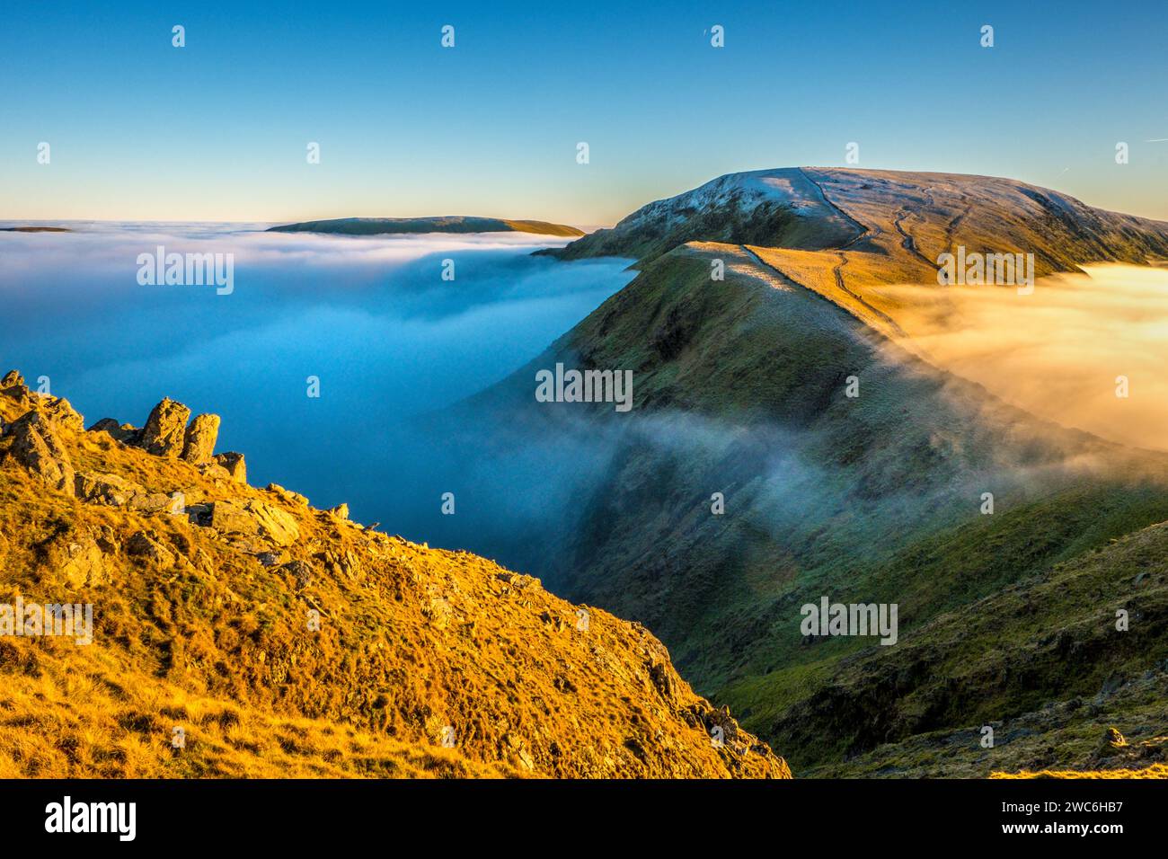 La catena montuosa di High Street nel Lake District National Park. Le colline si innalzano sopra un'inversione di nuvole Foto Stock