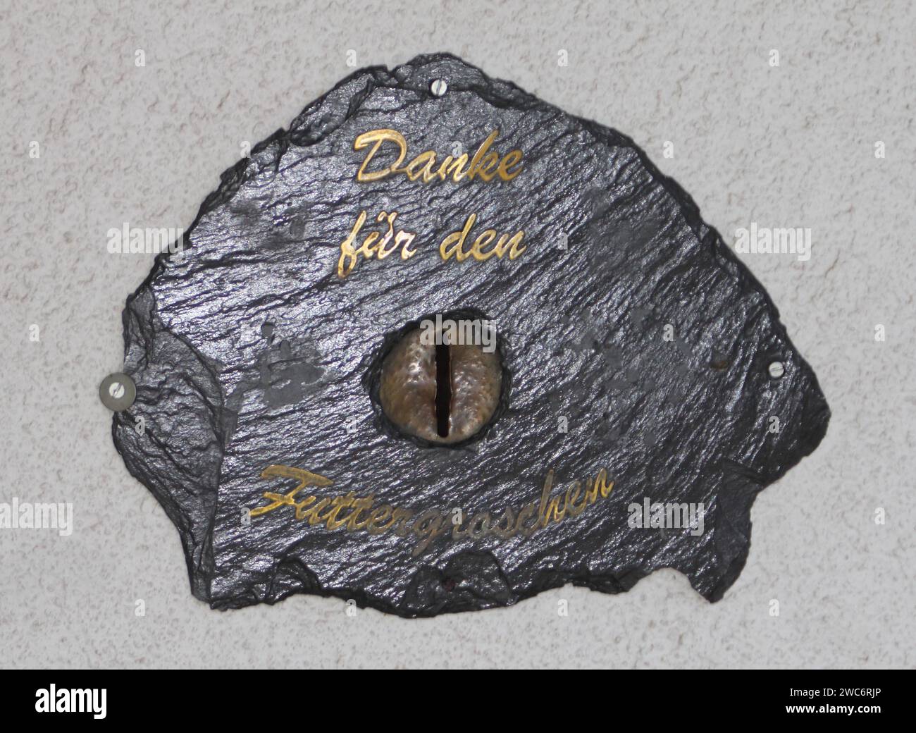 Un'ardesia con un'iscrizione e una fessura per monete Foto Stock