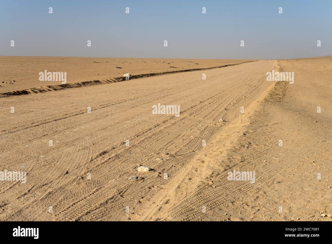 Paesaggio con strada di ghiaia nel mezzo del nulla nel deserto del paesaggio lunare , girato con una luce brillante di tarda primavera vicino a Swakopmund, Namibia, Africa Foto Stock