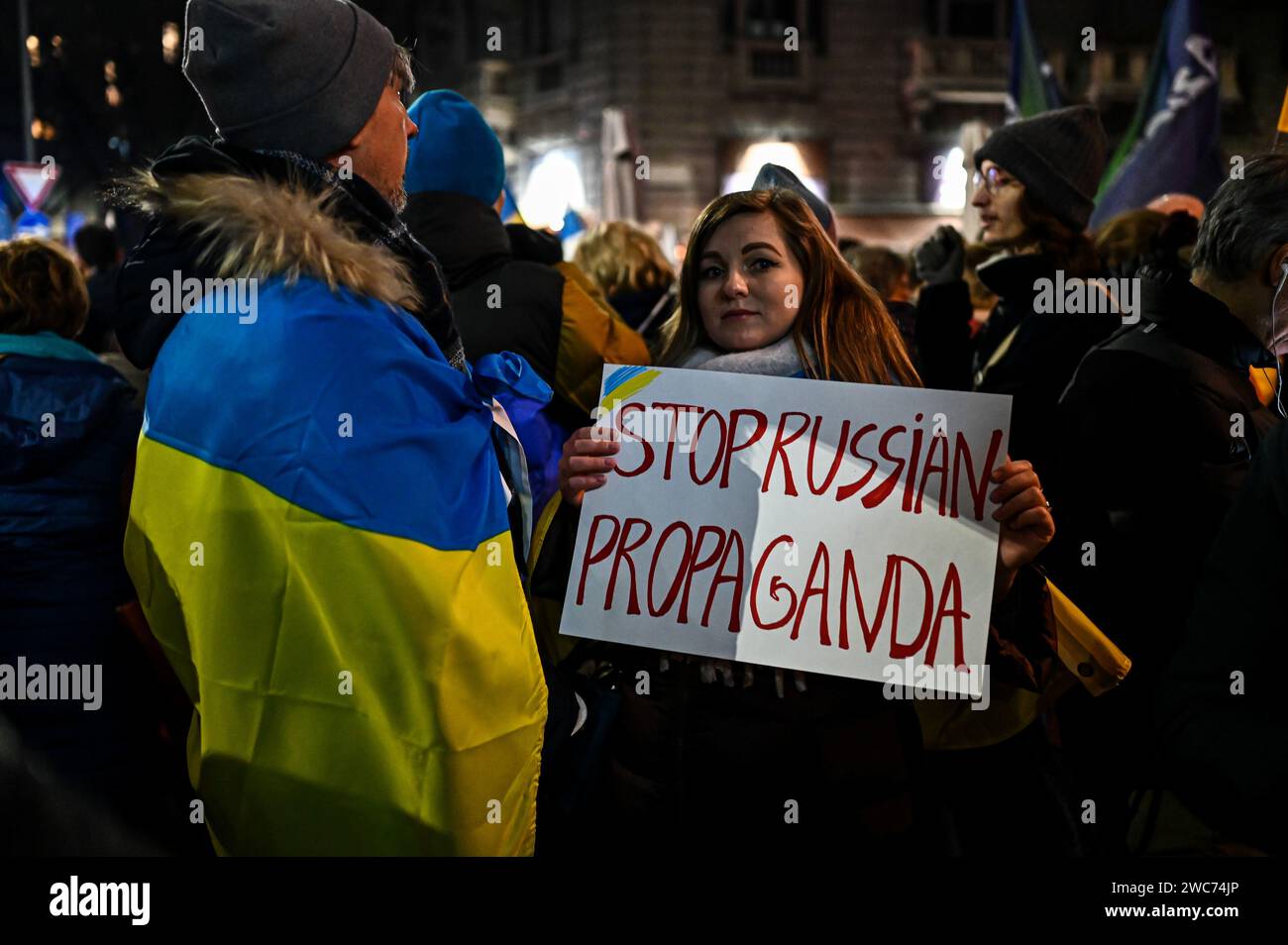 Milano, Italia il 14 gennaio 2024. Una donna che indossa una bandiera Ucraina ha un cartello con la scritta "Stop Russian propaganda" vicino alla libreria Ritter a Milano, Italia, il 14 gennaio 2024 per protestare contro un incontro su Darya Dugina, figlia del pensatore politico russo Aleksandr Dugin. Crediti: Piero Cruciatti/Alamy Live News Foto Stock