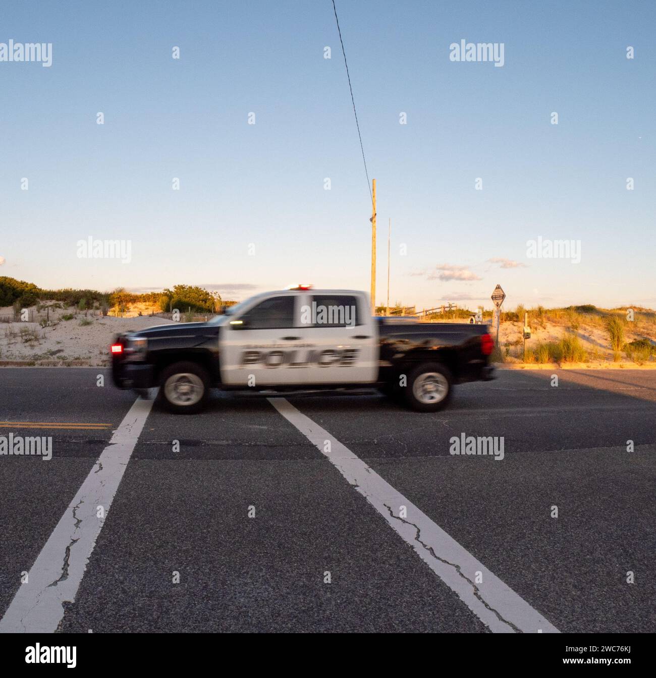 Un camion luminoso si muove lungo una strada urbana trafficata, illuminando l'ambiente circostante con i suoi vivaci fari Foto Stock