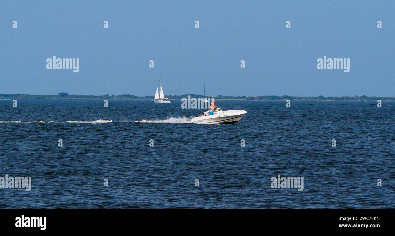 Due barche a vela scivolano graziosamente attraverso la vasta distesa dell'oceano aperto, le loro vele bianche che si librano nel vento Foto Stock
