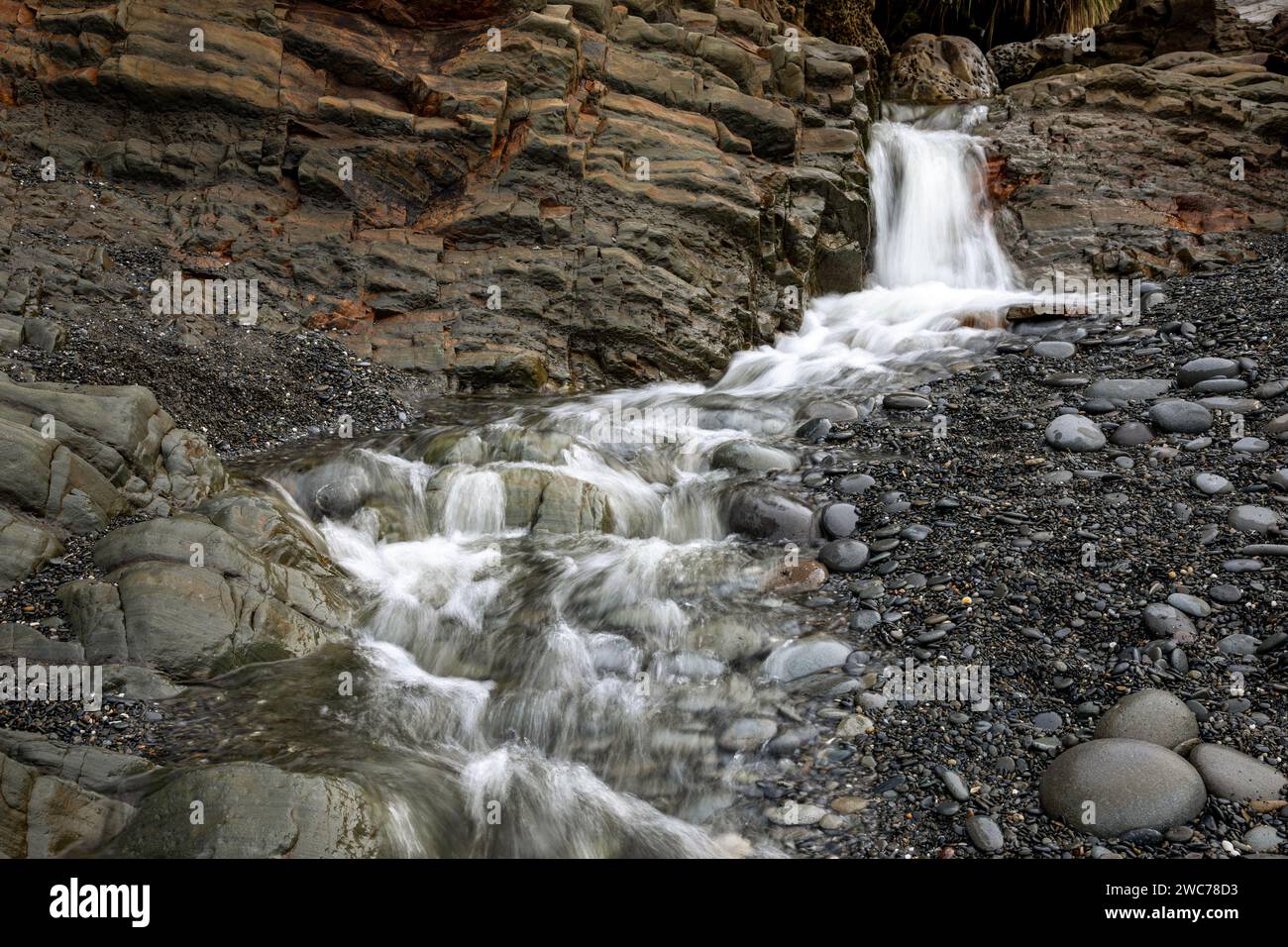 WA25023-00...WASHINGTON - piccolo torrente che si getta su un'arenaria stratificata che si estende sulla spiaggia 4 dell'Olympic National Park. Foto Stock