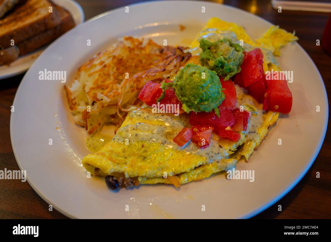 Una deliziosa colazione a buffet con omelette soffice, una varietà di frutta fresca, patate perfettamente tostate e broccoli nutrienti Foto Stock