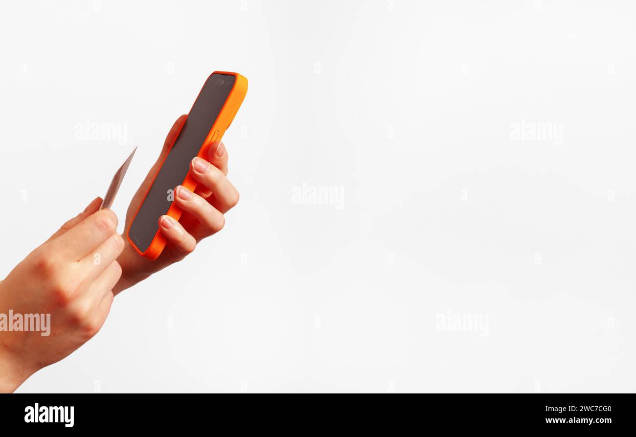 Mockup con schermo del telefono cellulare, pagamento con app bancaria, carta di debito in plastica in mano, vista angolare Foto Stock