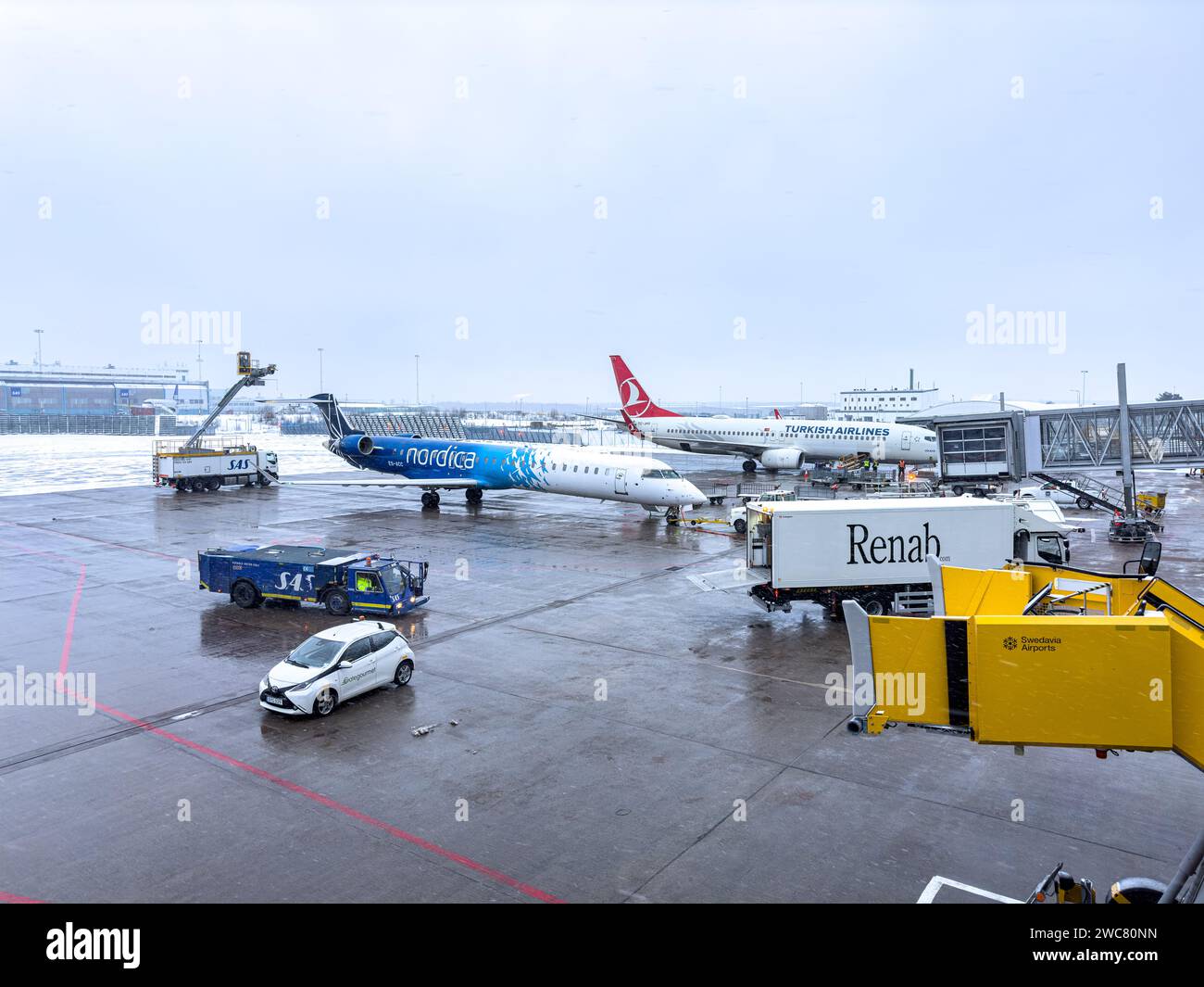 Aerei sull'asfalto dell'aeroporto di Helsinki in attesa di essere sghiacciati durante una tempesta di neve Foto Stock