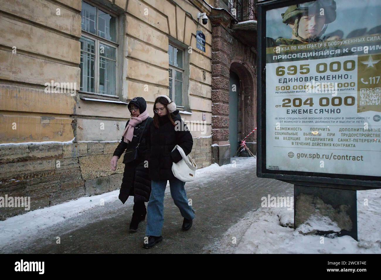 St Pietroburgo, Russia. 14 gennaio 2024. La gente passa davanti a un cartellone che promuove il servizio militare nell'esercito russo con l'iscrizione "contratto di servizio nelle forze armate". Unisciti al tuo" a San Pietroburgo. (Immagine di credito: © Artem Priakhin/SOPA Images via ZUMA Press Wire) SOLO USO EDITORIALE! Non per USO commerciale! Foto Stock