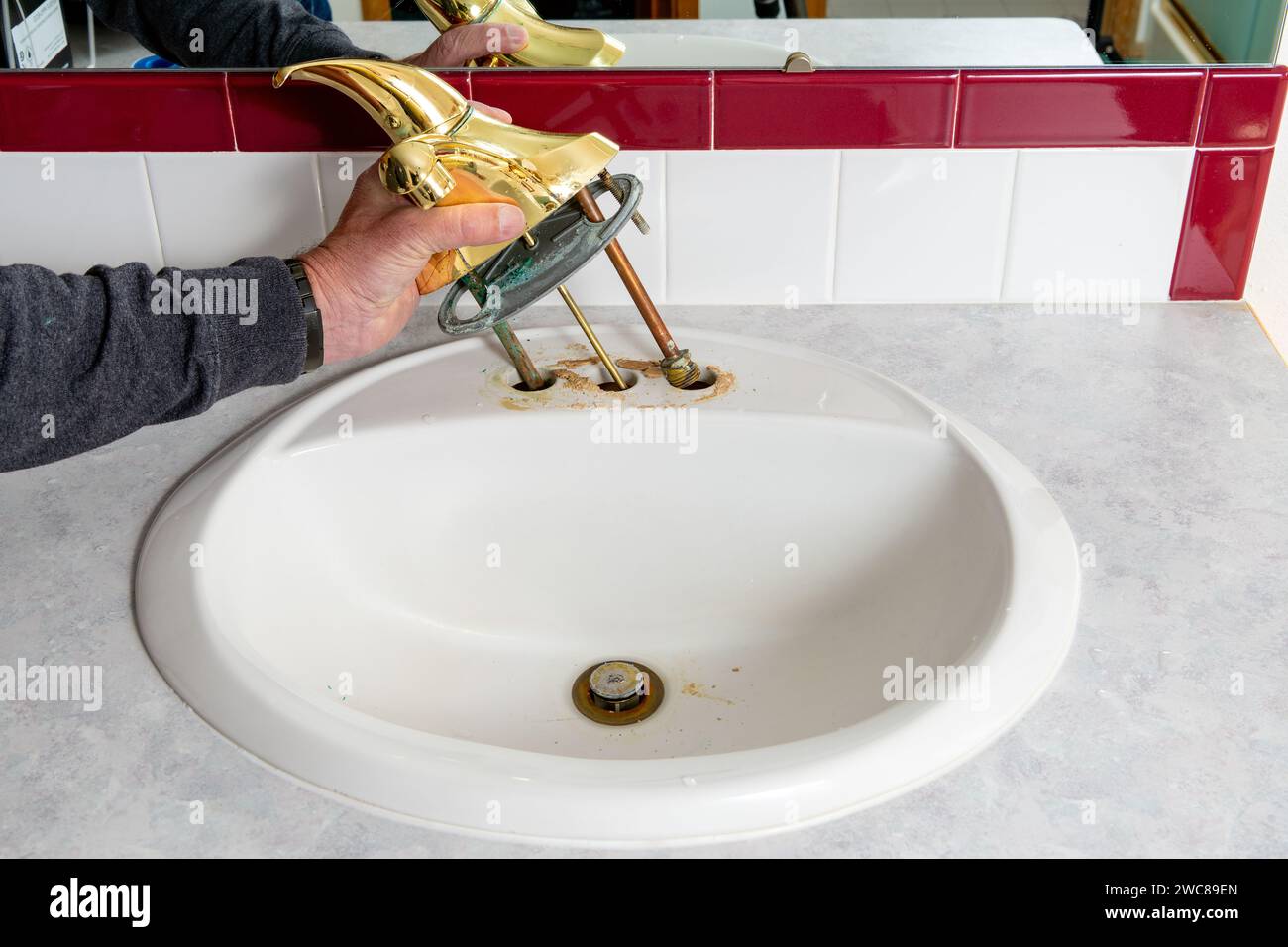 Rimozione del lavandino del rubinetto in bagno in ambienti interni Foto Stock