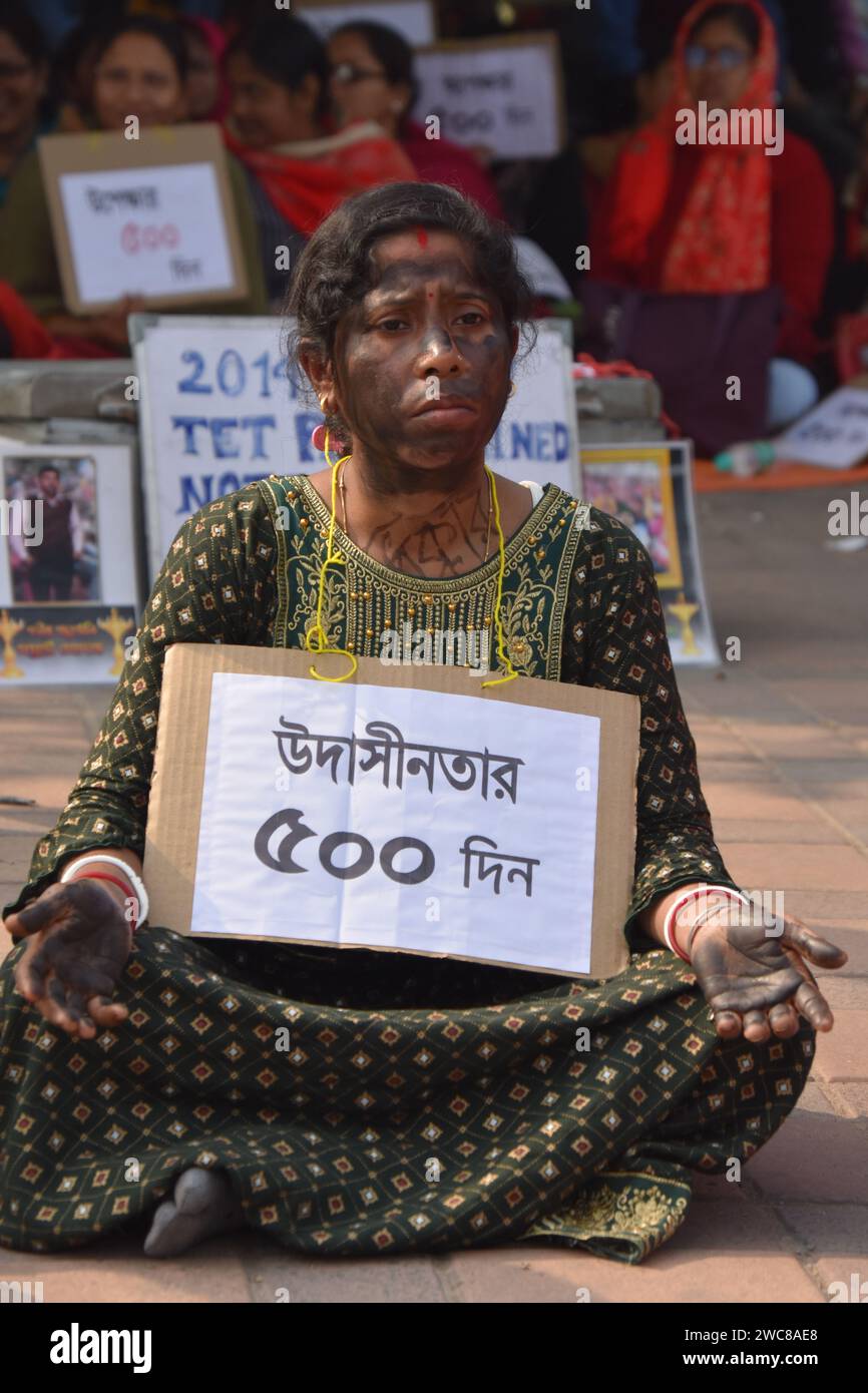 Calcutta, Bengala Occidentale, India. 14 gennaio 2024. Oggi ricorre il 500° giorno di una manifestazione in corso mentre il test di idoneità degli insegnanti (TET) primario del Bengala Occidentale del 2014 ha superato gli insegnanti addestrati si riuniscono in unità ai piedi della statua Matangini Hazra a Calcutta, sotto la bandiera di ''Ekota Mancho'' (unità).i manifestanti, tra gli individui che hanno superato con successo il TET primario del Bengala Occidentale del 2014 ma non sono stati inclusi nella forza lavoro didattica, sono stati fermi nella loro domanda di opportunità di lavoro. L'iconica statua Matangini Hazra è diventata un simbolo della loro perseveranza e.. Foto Stock