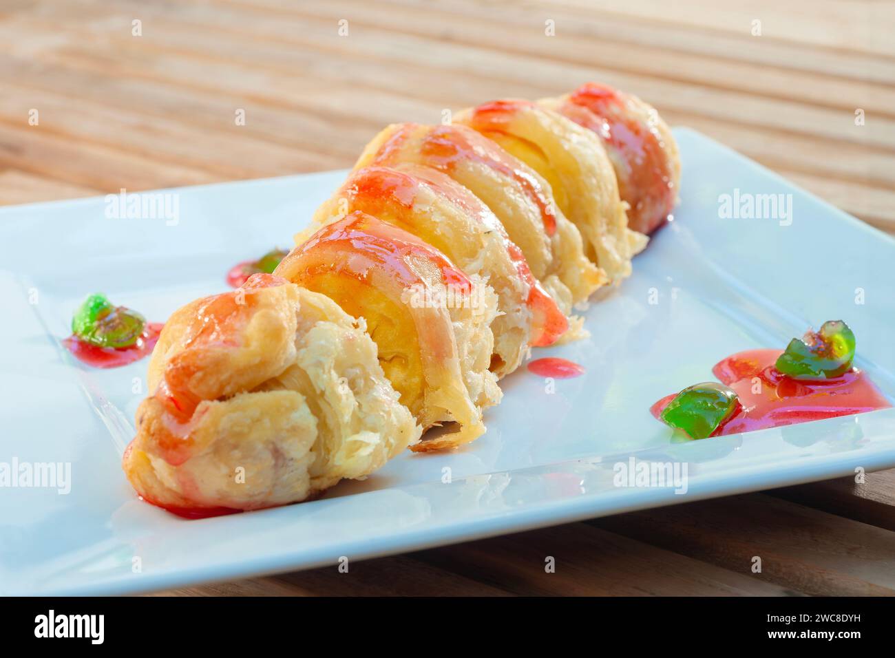 Banana Roll Puff terbuat dari Pisang yang di tutupi dengan tepung terigu dan dilumuri fragola di sirup Foto Stock