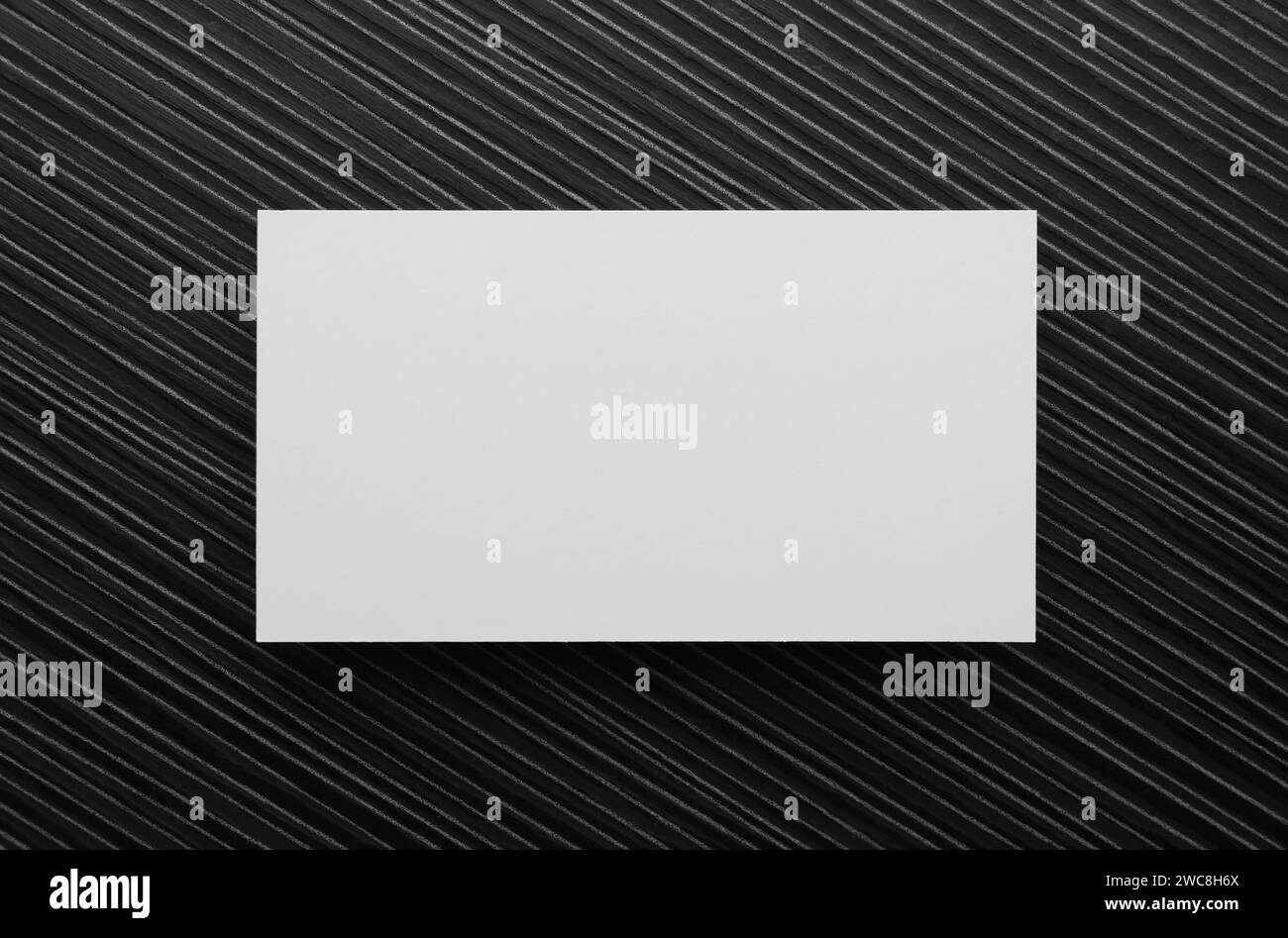 Biglietto da visita vuoto su tavolo in legno nero, vista dall'alto. Mockup per il design Foto Stock