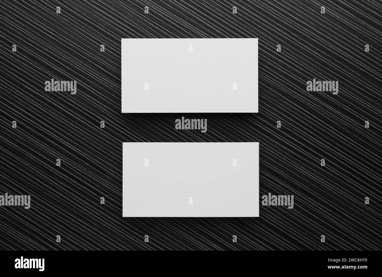 Biglietti da visita vuoti su un tavolo di legno nero, piatti. Mockup per il design Foto Stock