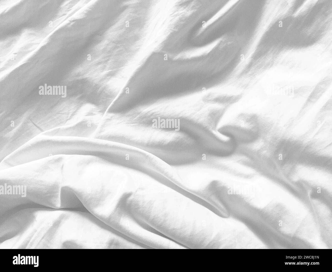 Uno sfondo in tessuto bianco immacolato che mostra la lussuosa texture della seta, crea un'atmosfera astratta e morbida, perfetta per un design di alto livello. Foto Stock