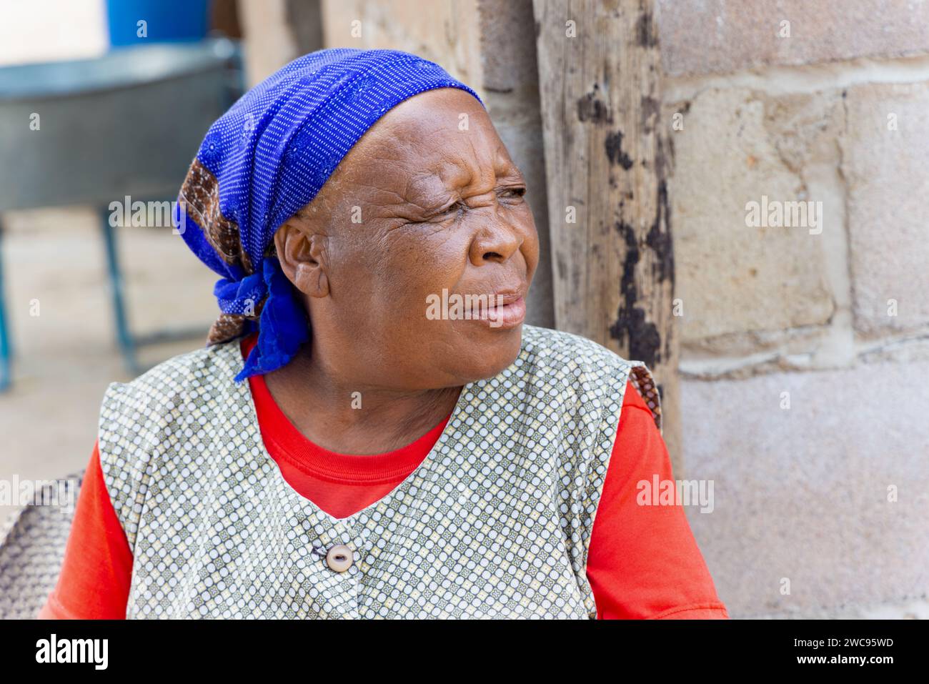 Ritratto di una vecchia donna africana seduta nel cortile, villaggio in Botswana Foto Stock