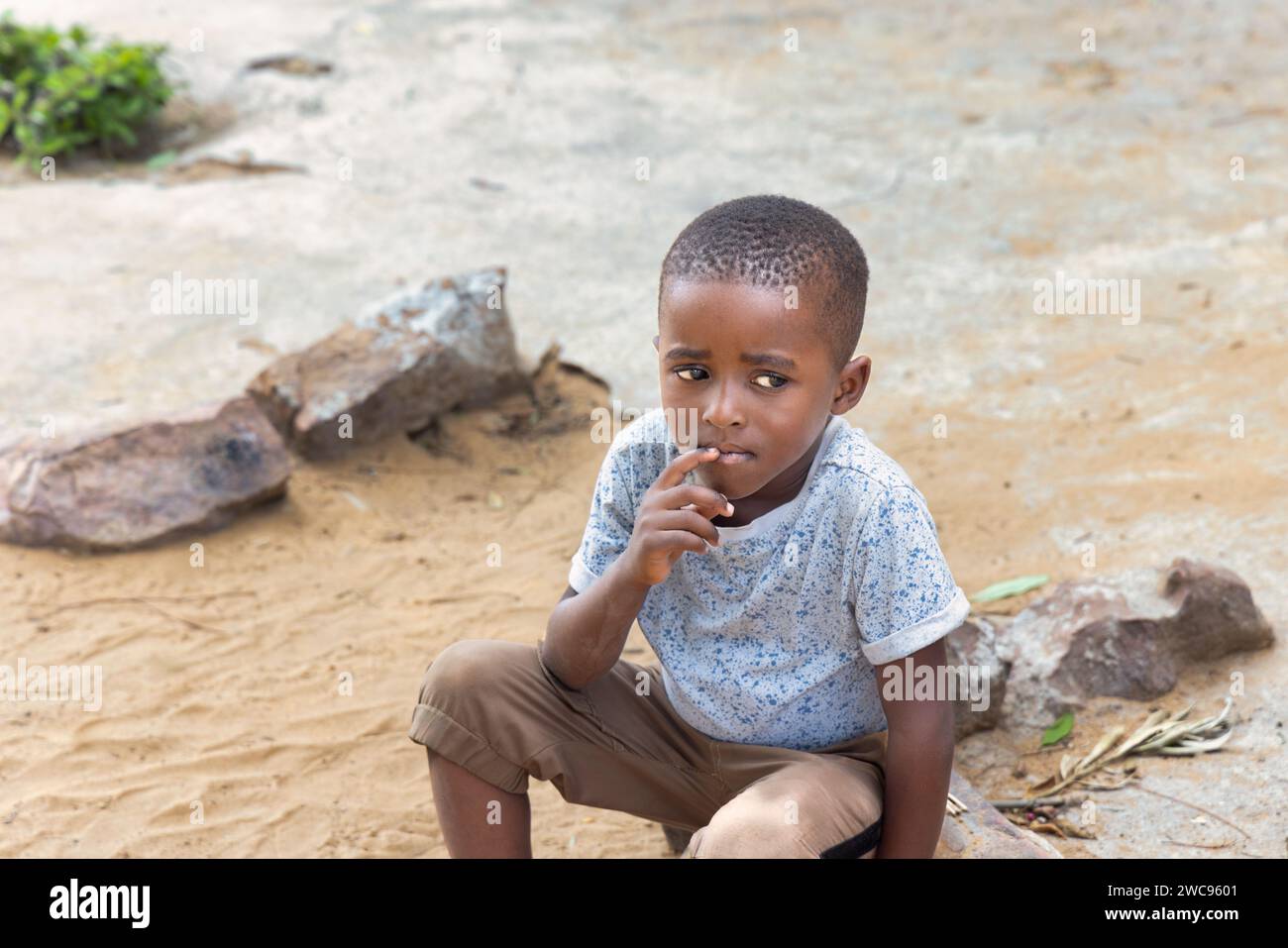 Ritratto di un bambino africano seduto nel cortile, villaggio in Botswana Foto Stock